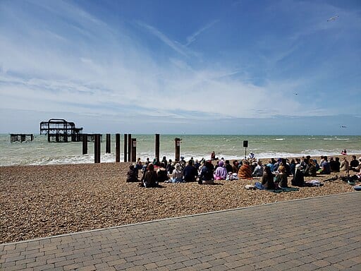 Menschengruppe meditierend am Strand